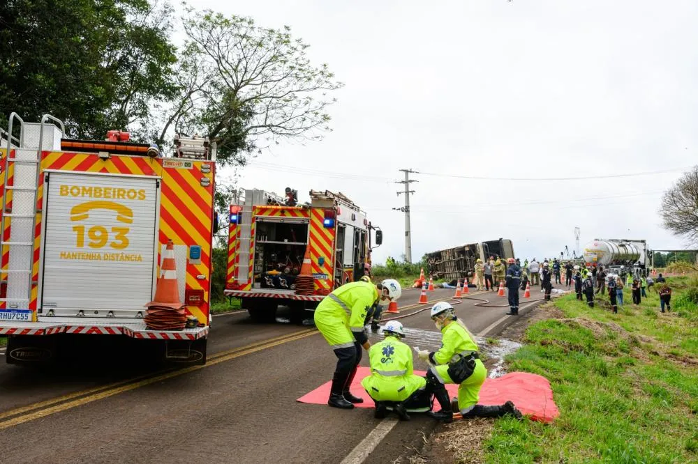 Socorristas atendem vítima simulada na pista enquanto viaturas do Corpo de Bombeiros, ônibus tombado e carreta-tanque compõem o cenário do simulado na PR-180, em Cascavel. Foto: Divulgação