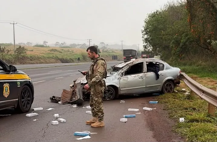 Veículo capotou durante fuga na BR-163 e carga de cigarros ficou espalhada na pista.